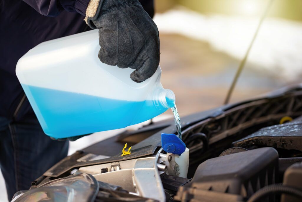 personne versant du liquide de refroidissement dans son réservoir